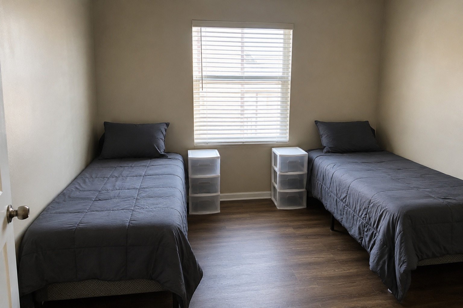 Representative shared bedroom with two twin beds and small plastic drawer units